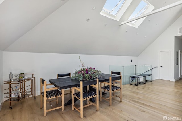 dining space featuring light hardwood / wood-style floors and lofted ceiling