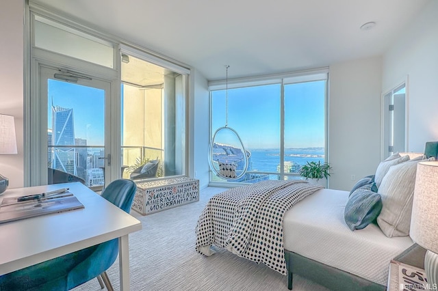 bedroom featuring a water view, multiple windows, and carpet floors