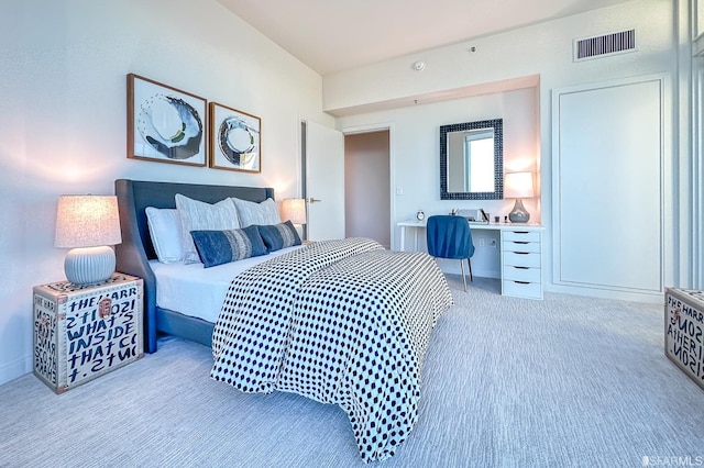 carpeted bedroom featuring built in desk