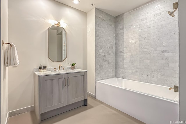 bathroom featuring tiled shower / bath and vanity