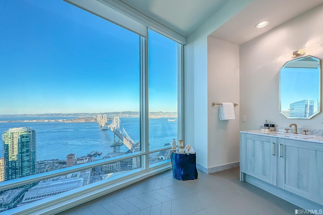 bathroom with a wealth of natural light, tile patterned floors, and a water view