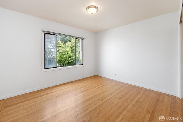 empty room with baseboards and light wood finished floors