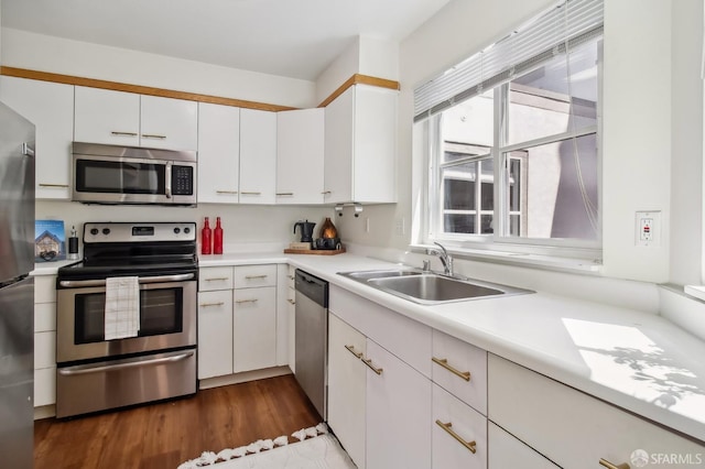 1945 Washington St Unit 412, San Francisco, CA 94109 - kitchen with appliances with stainless steel finishes, a sink, light countertops, white cabinetry, and dark wood-style flooring