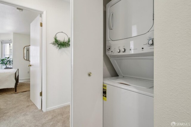 1945 Washington St Unit 412, San Francisco, CA 94109 - washroom with estacked washer and dryer, light colored carpet, and baseboards