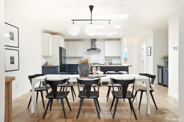 1643 43rd Ave, San Francisco, CA 94122 - kitchen featuring wall chimney range hood, backsplash, white cabinetry, pendant lighting, and freestanding refrigerator