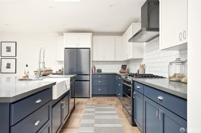1643 43rd Ave, San Francisco, CA 94122 - kitchen with wall chimney exhaust hood, appliances with stainless steel finishes, white cabinets, tasteful backsplash, and a center island with sink