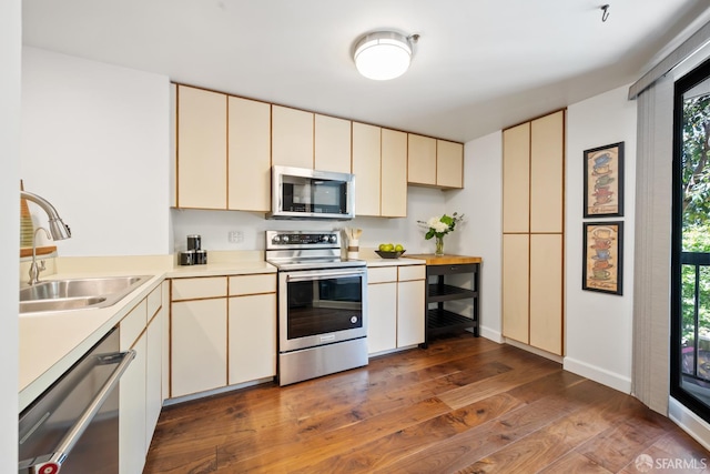 601 Van Ness Ave Unit 35, San Francisco, CA 94102 - kitchen featuring stainless steel appliances, cream cabinetry, light countertops, dark wood finished floors, and healthy amount of natural light