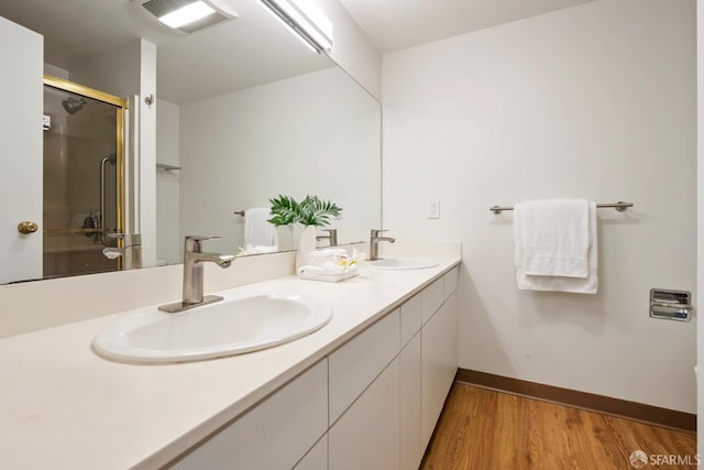 601 Van Ness Ave Unit 35, San Francisco, CA 94102 - bathroom featuring double vanity, wood finished floors, and an enclosed shower
