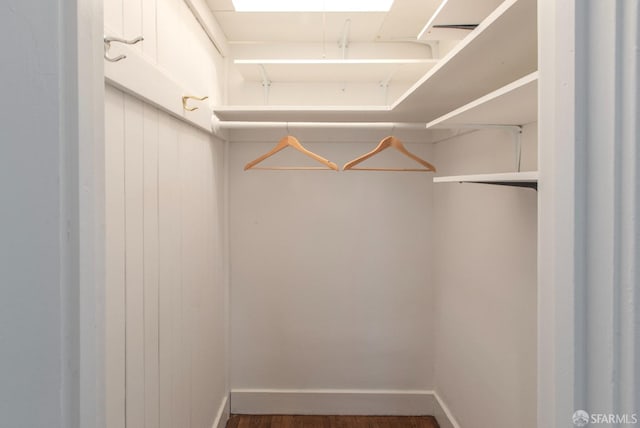 walk in closet with wood finished floors