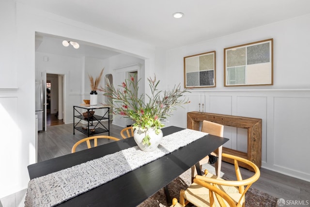 dining area with a decorative wall, recessed lighting, a wainscoted wall, and wood finished floors