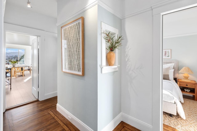 corridor featuring wood finished floors and baseboards