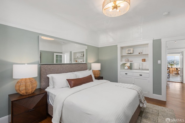 bedroom with baseboards and wood finished floors