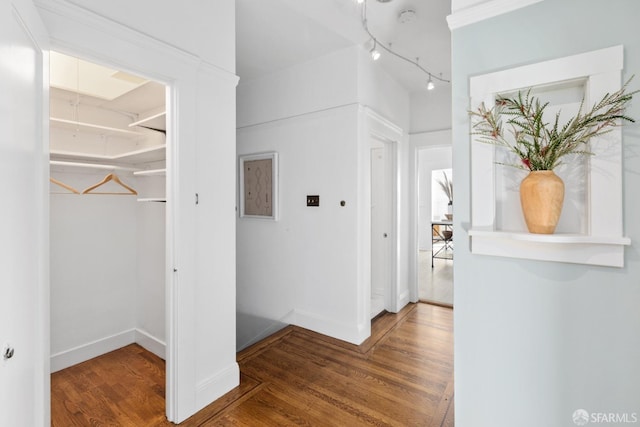 hallway featuring baseboards and wood finished floors