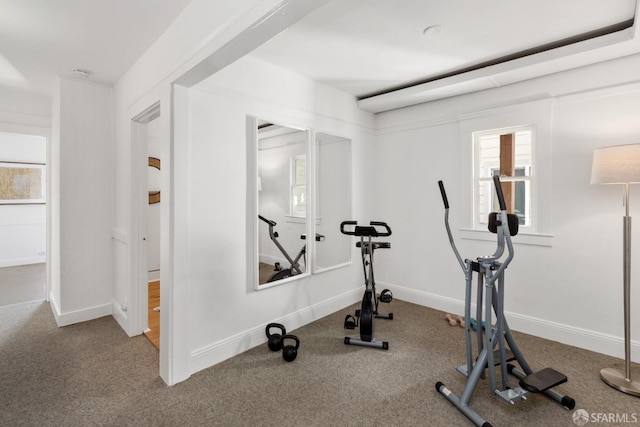 exercise room with baseboards and carpet