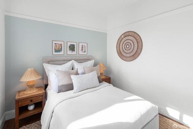 bedroom with wood finished floors and baseboards