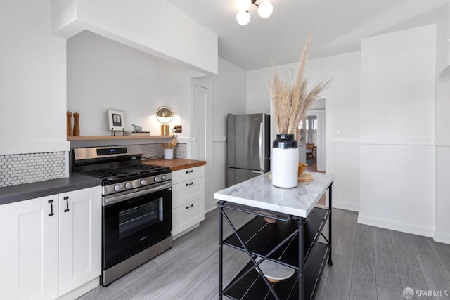 kitchen featuring white cabinetry, appliances with stainless steel finishes, wooden counters, and light wood finished floors