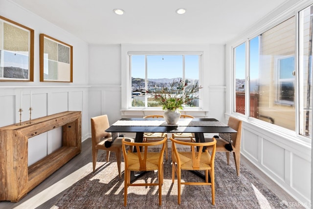 dining space featuring recessed lighting, wood finished floors, and a decorative wall