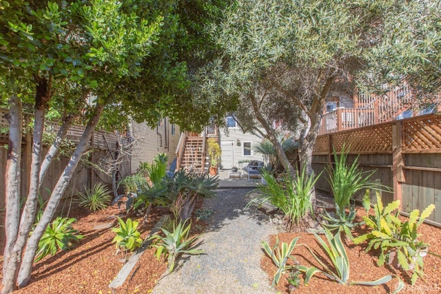 view of yard with stairway, a fenced backyard, and a patio area