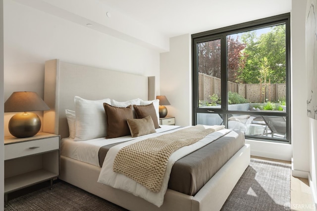 bedroom with multiple windows and hardwood / wood-style floors