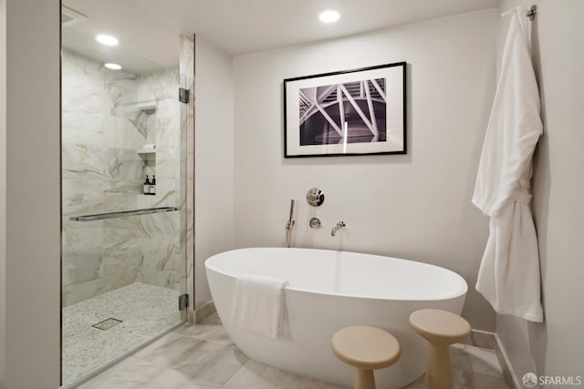 bathroom featuring shower with separate bathtub