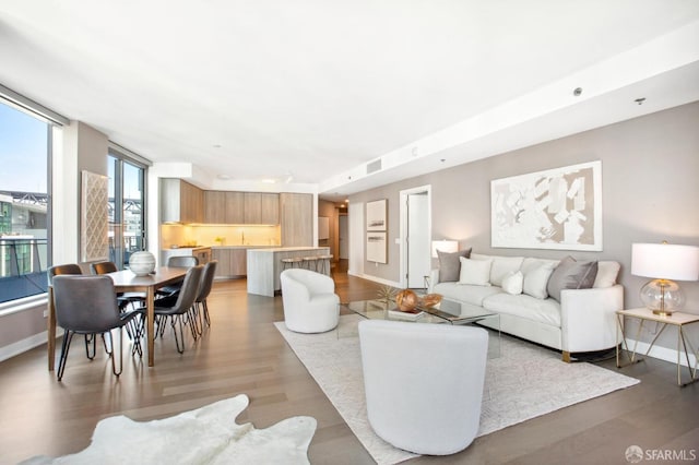 living area with visible vents, baseboards, and light wood finished floors