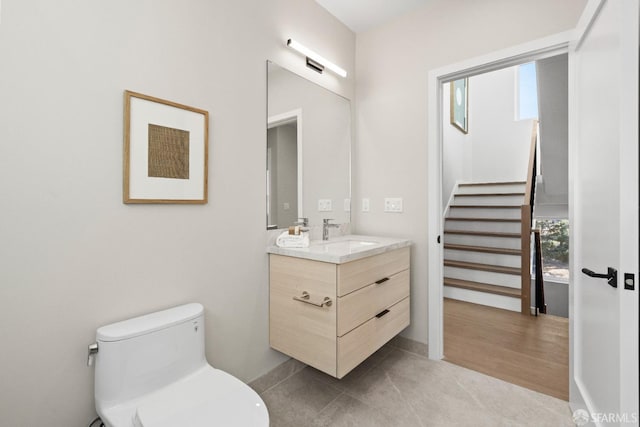 bathroom with plenty of natural light, toilet, vanity, and tile patterned floors