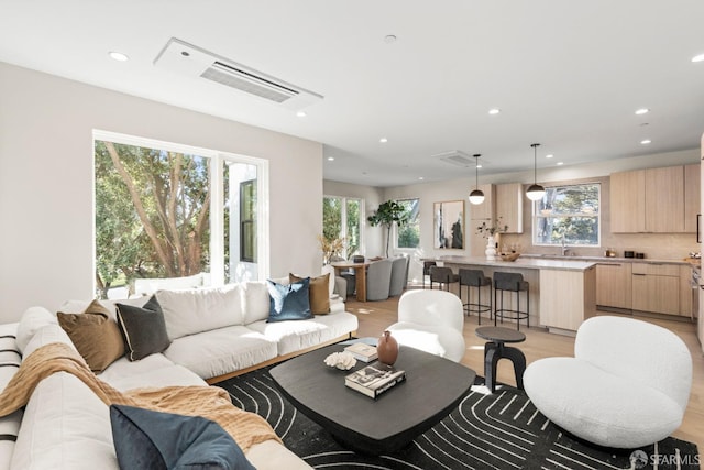 living room with recessed lighting and light wood-style flooring