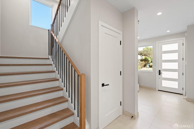 staircase featuring baseboards, recessed lighting, and tile patterned floors