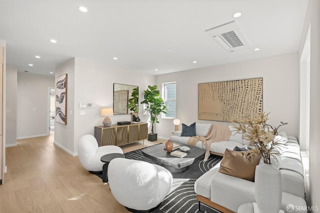 living room with light wood-style floors, recessed lighting, and baseboards