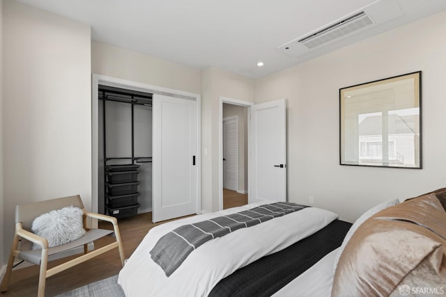 bedroom featuring wood finished floors, recessed lighting, and a closet