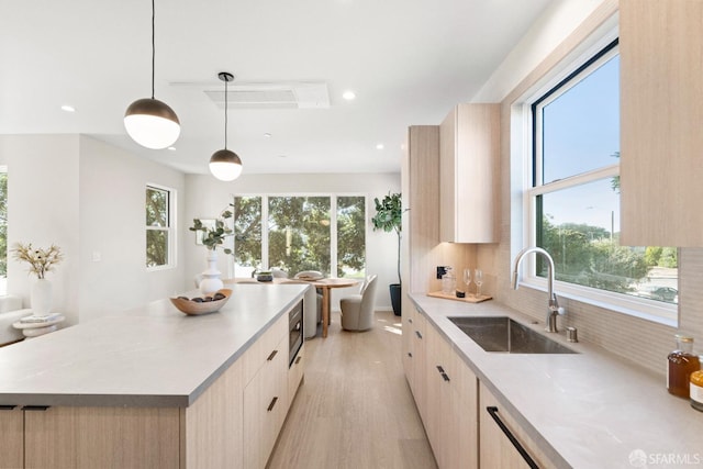 kitchen featuring a sink, light brown cabinets, modern cabinets, light wood-style floors, and recessed lighting