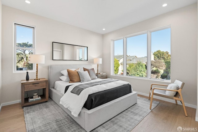 bedroom featuring baseboards, multiple windows, light wood-type flooring, and recessed lighting