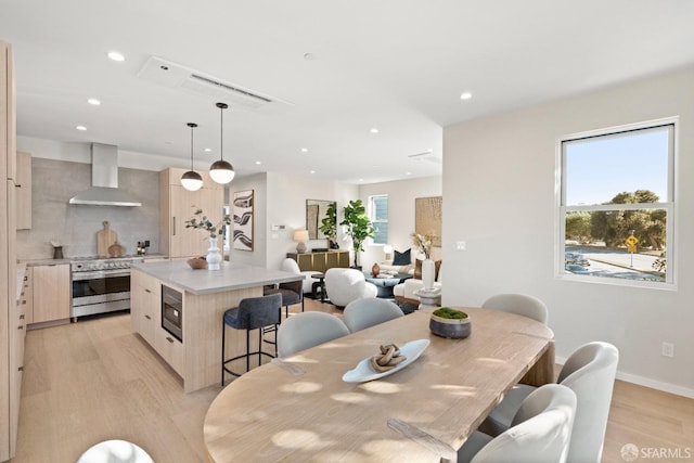 dining space featuring light wood finished floors, recessed lighting, and baseboards