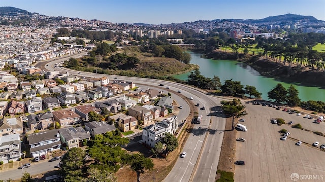 view of property location featuring a water and mountain view and nearby suburban area