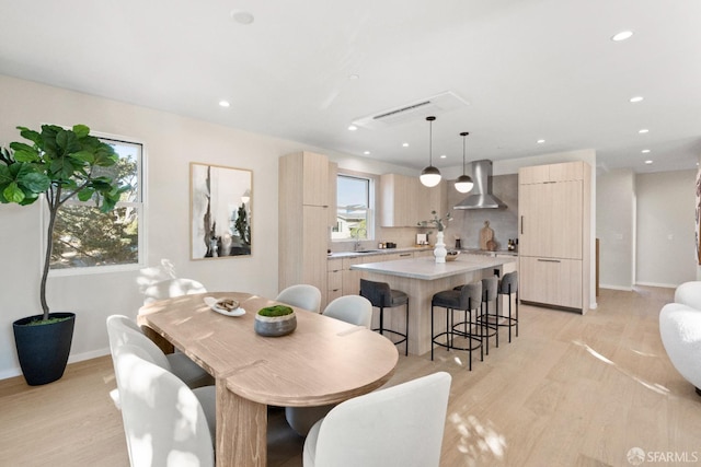 dining area with light wood-style floors, recessed lighting, and baseboards