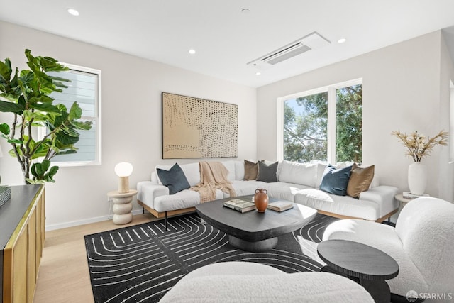 living area featuring light wood-style flooring, recessed lighting, and baseboards