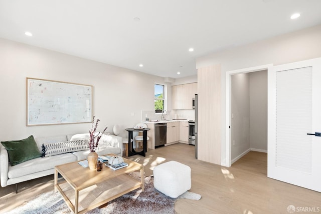 living room with light wood-style flooring, recessed lighting, and baseboards