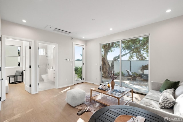 living room with light wood finished floors, recessed lighting, and baseboards