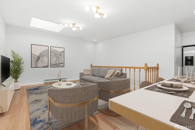 3870 18th St, San Francisco, CA 94114 - living area featuring a baseboard radiator, a skylight, wood finished floors, and baseboards