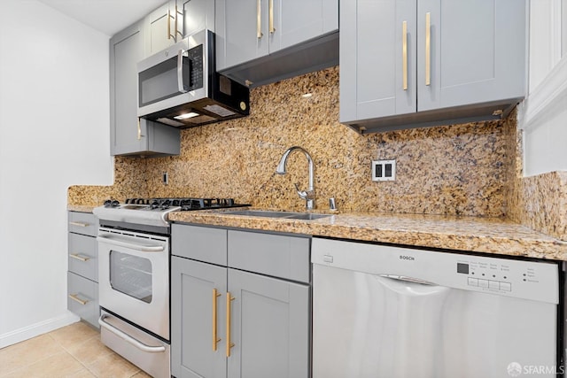 3870 18th St, San Francisco, CA 94114 - kitchen with appliances with stainless steel finishes, a sink, tasteful backsplash, gray cabinetry, and light stone counters