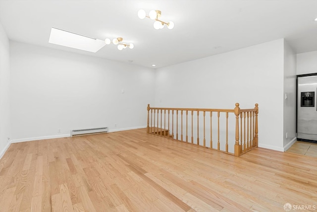 3870 18th St, San Francisco, CA 94114 - unfurnished room with baseboard heating, a skylight, light wood finished floors, and baseboards