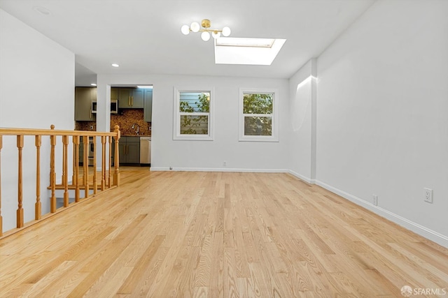 3870 18th St, San Francisco, CA 94114 - unfurnished room with a skylight, light wood-type flooring, a sink, and baseboards