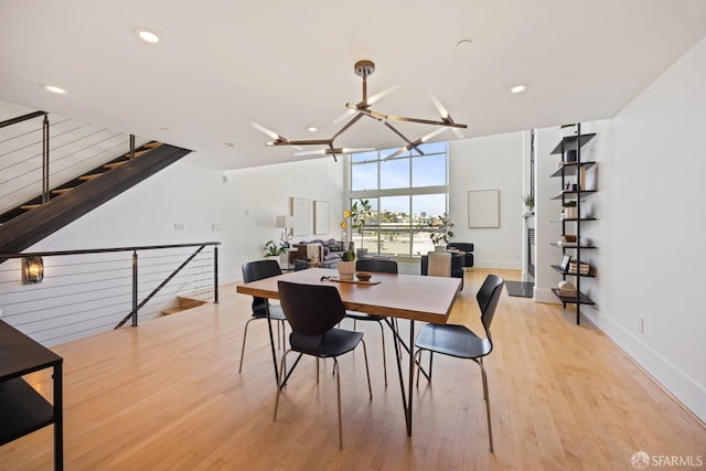 dining area with light wood-type flooring, baseboards, a notable chandelier, and recessed lighting