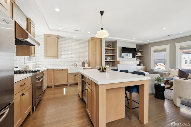 3226 Octavia St, San Francisco, CA 94123 - kitchen with stainless steel appliances, light brown cabinetry, open floor plan, a breakfast bar area, and light wood-style floors