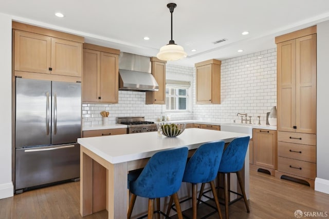 3226 Octavia St, San Francisco, CA 94123 - kitchen with stainless steel fridge, stove, wall chimney range hood, a sink, and a center island