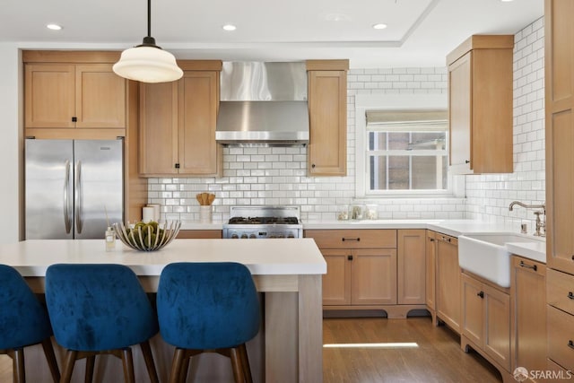 3226 Octavia St, San Francisco, CA 94123 - kitchen with freestanding refrigerator, wall chimney range hood, a sink, a breakfast bar area, and range with gas stovetop
