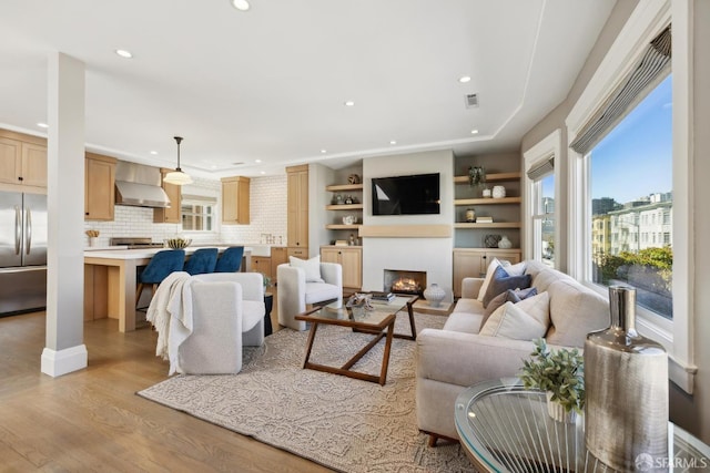 3226 Octavia St, San Francisco, CA 94123 - living area with light wood-style flooring, recessed lighting, and a warm lit fireplace