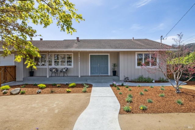 single story home featuring board and batten siding, a porch, and a shingled roof