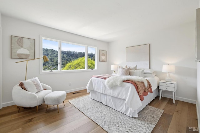 bedroom featuring visible vents, baseboards, and light wood-style floors