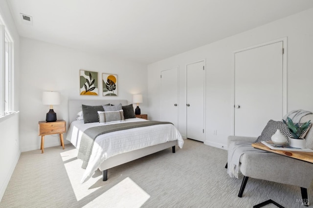 bedroom with light colored carpet, baseboards, and visible vents